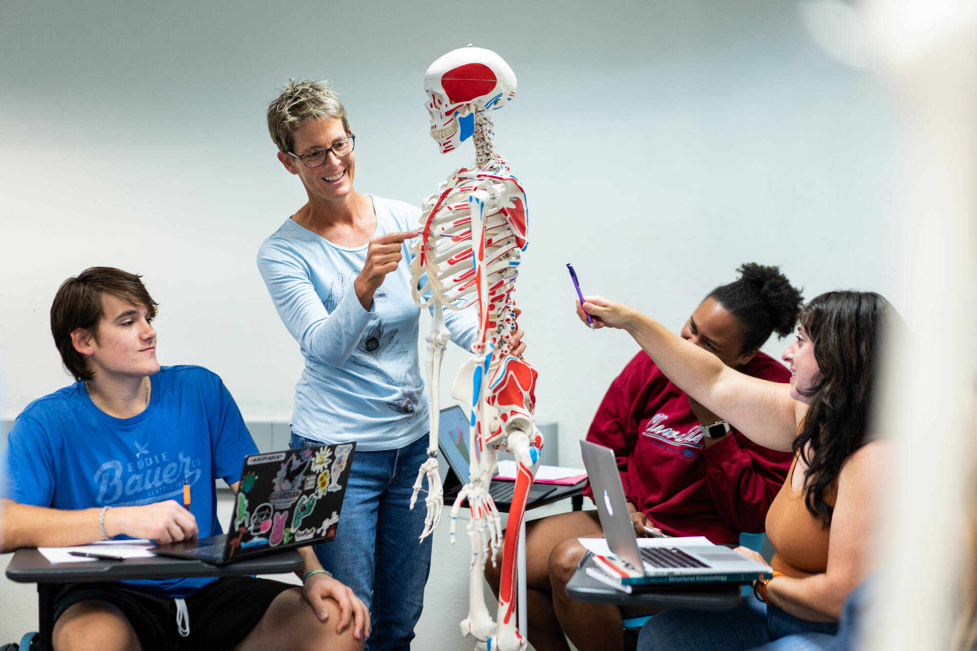 professor and student pointing at skeleton
